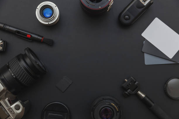 istock Photographer workplace with dslr camera system, camera cleaning kit, lens and camera accessory on dark black table background 1175014980