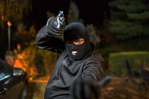 istock Man in skin mask holding gun 1175017324