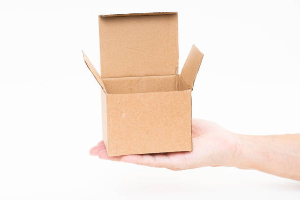 istock Man hand holding brown paper box on white background 1175020657