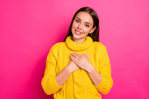istock Portrait of charming lady in soft warm pullover touching her chest with, palm isolated over fuchsia background 1175021057