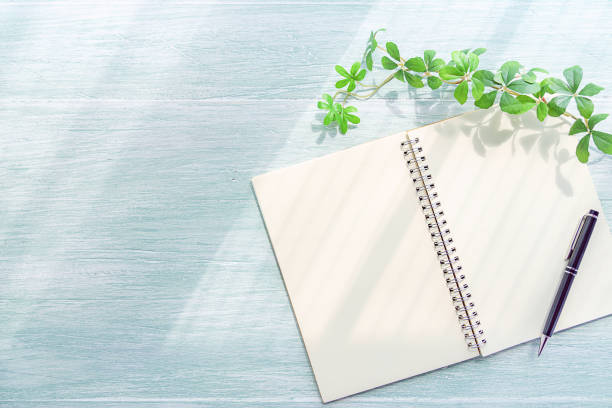 istock Notebook and pen on wooden background 1175021138