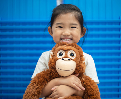 Little girl holding a orangutan plush toy