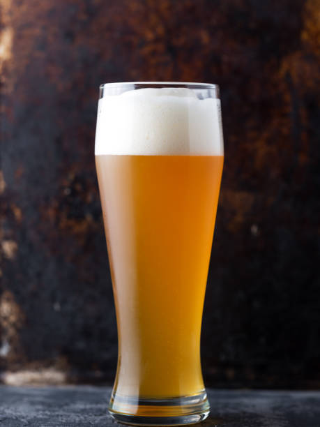 nahaufnahme des traditionellen vollen glases ungefiltertem weizenbier auf braunen alten dunklen hintergrund - weizenbier stock-fotos und bilder