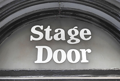 Stage Door sign in white letters.