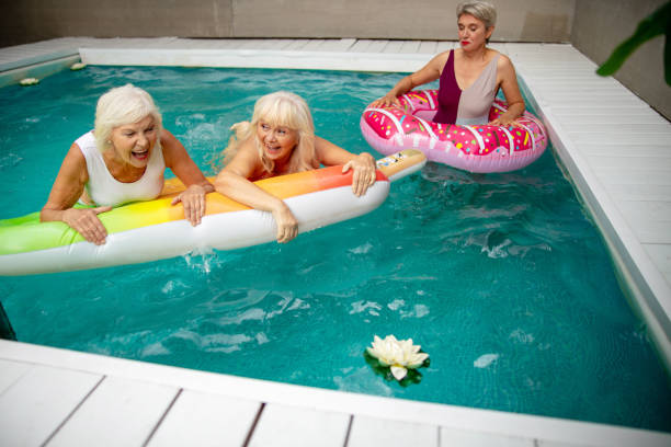 istock Three joyful mature women swimming in the pool 1175024737