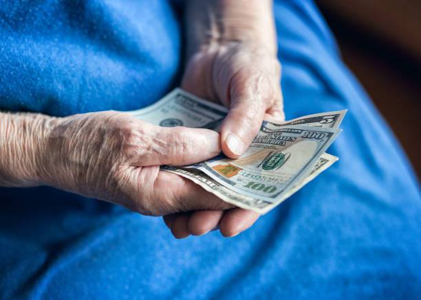 istock Elderly man holding money in his hand. 1175026829
