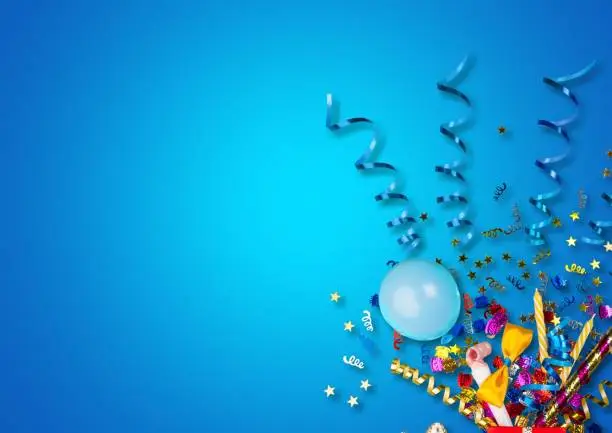 Colorful balloons and confetti on blue table