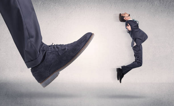 istock Small businessman kicked by big shoe 1175032001