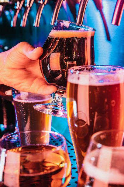 istock Hand of bartender pouring a large lager beer in tap 1175032009