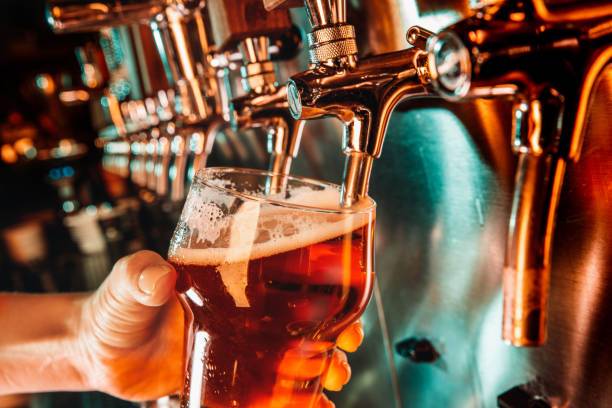 istock Hand of bartender pouring a large lager beer in tap 1175032105