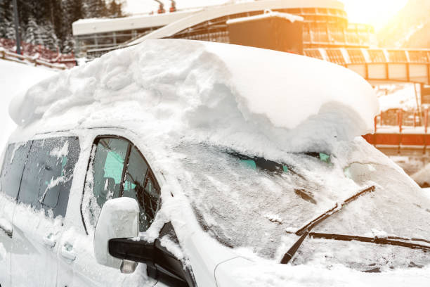 coche en una calle cubierta de gran capa de nieve gruesa después de fuertes nevadas. consecuencias de la ventisca extrema. parabrisas del vehículo con ventana congelada y limpiaparabrisas - thick snow fotografías e imágenes de stock