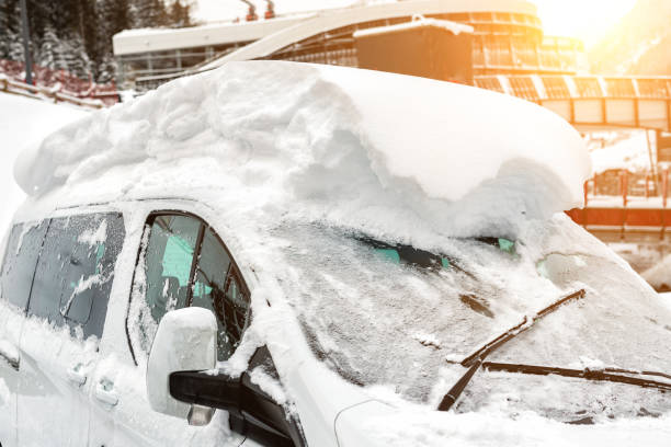 автомобиль на улице, покрытой большим толстым слоем снега после сильного снегопада. экстремальные последствия метели. лобовое стекло авто� - thick snow стоковые фото и изображения