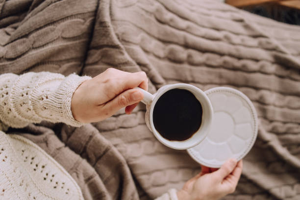 istock student girl warm home clothes bed coffee 1175033121