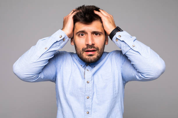 istock handsome man happy smile looking at camera, hold hands on head isolated on gray background. 1175033983