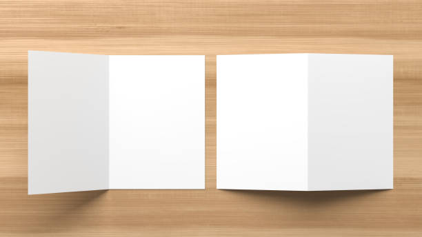 istock Realistic bi fold brochure or invitation mock up isolated on wooden background. 3D illustration. 1175035532