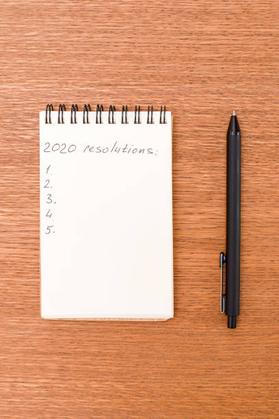 istock Notebook for recording purposes for 2020 on wooden desk 1175037295