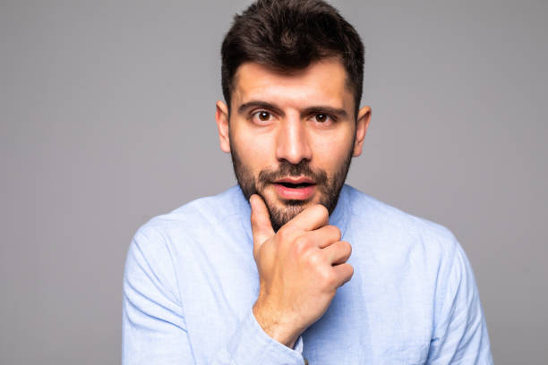 istock Young handsome man with hand on chin thinking about question, pensive expression over isolated gray background. Smiling with thoughtful face. Doubt concept. 1175037548