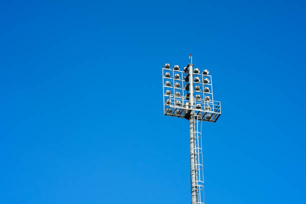 Spotlight tower for sport stadium like football, soccer or ruby, with background of clearly blue sky. Telephoto at the object.