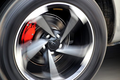 Red brake calipers on a fast-moving car