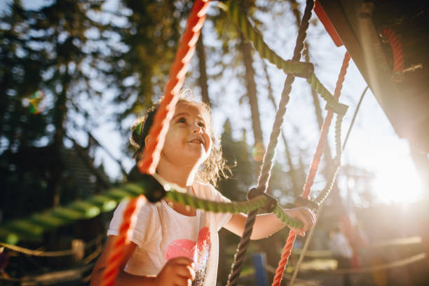 One step at a time Cute little girl in a playground climbing ropes jungle gym stock pictures, royalty-free photos & images