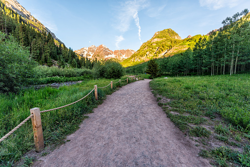 Maroon Bells wide angle view in Aspen, Colorado with peak and snow in July 2019 summer and trail path road with nobody