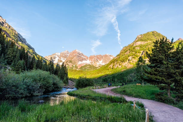 maroon bells vista ad aspen, colorado con picco e neve nel luglio 2019 estate e sentiero strada con fiume che scorre - maroon foto e immagini stock