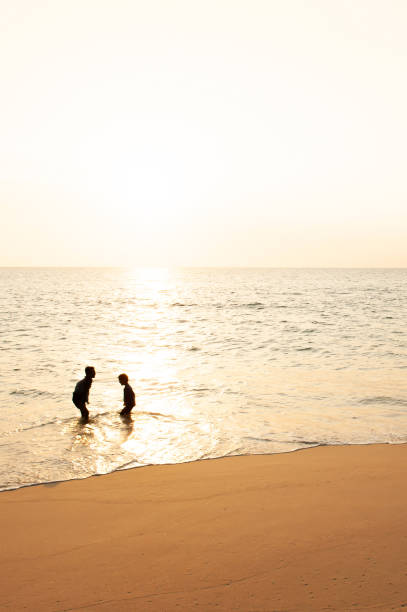 istock Happy two asian boys playing and laughing on the sunset beach. 1175044889