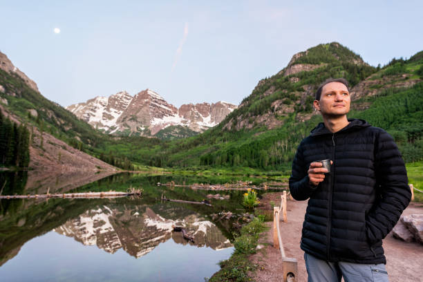 maroon bells lake in aspen, colorado at blue hour in july 2019 summer and moon reflection at sunrise with man drinking coffee or tea in morning - 15855 imagens e fotografias de stock