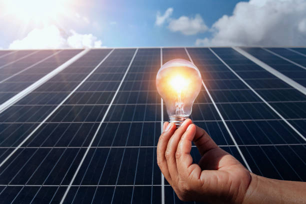 istock hand holding lightbulb on solar panel concept clean energy in nature 1175049067