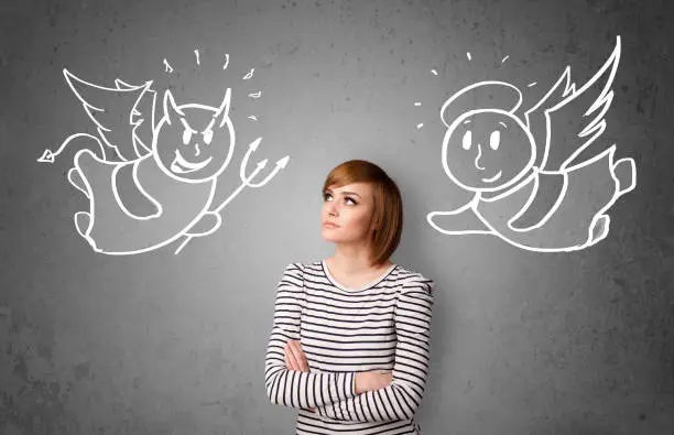 Photo of Woman standing between the angel and the devil