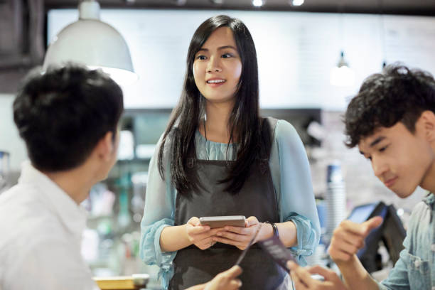 istock Barista with digital tablet advising customers 1175049263