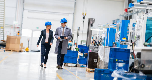 istock Two Engineers Walking Through An Automated Factory And Talking 1175050087