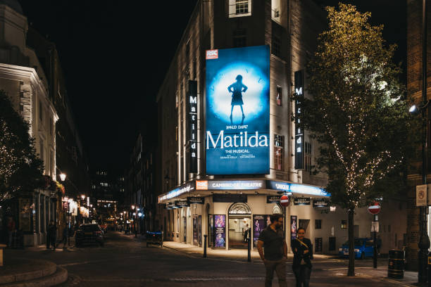 Illuminated facade of Cambirdge Theatre located on Seven Dials, London, UK, showing Matilda musical. stock photo