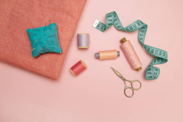 istock Sewing accessories and fabric on pink background. 1175050778