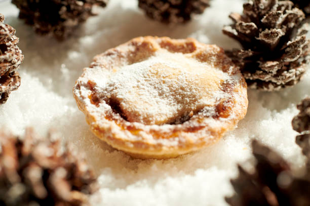 istock Single Mince Pie with Christmas decoration Pine cones on a snow background. 1175050833