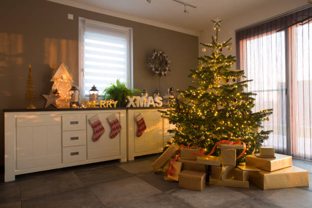 decorated christmas fir tree in apartment modern living room with christmas tree, presents and other festive decoration during day time sideboard photos stock pictures, royalty-free photos & images