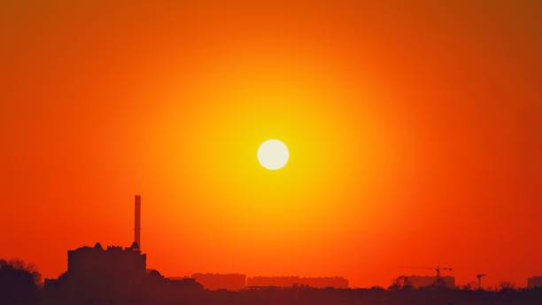 soleil chaud de canicule. le réchauffement climatique llimate changement. fond d'été avec un soleil d'été magnifique. coucher du soleil d'automne. le soleil couchant dans un ciel clair. concept chaud de temps de ville. température élevée en été. - clear sky flash photos et images de collection