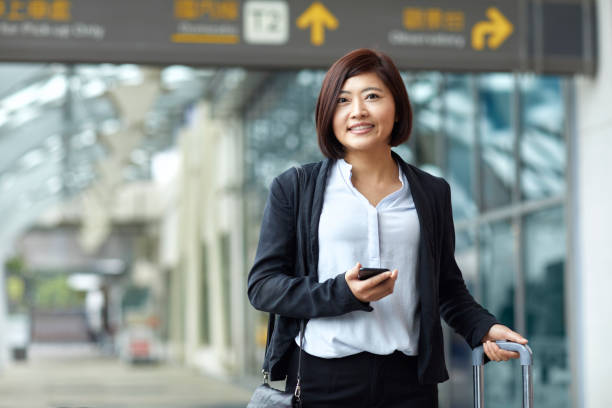 Smiling professional with smart phone in airport