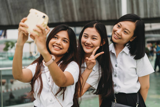 drei studentenfreunde, die mit einer instantkamera ein selfie in der stadt machen - polaroid transfer fotos stock-fotos und bilder