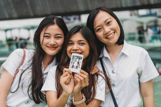 drei studentenfreunde zeigen ein bild vor die kamera - polaroid transfer fotos stock-fotos und bilder