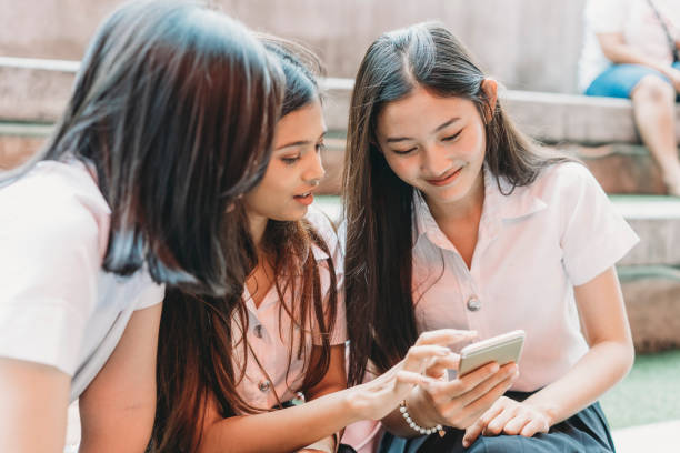 istock Three student friends using a mobile phone together in the city 1175056318