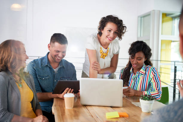 istock Multi ethnic group of succesful creative business people using a laptop during candid meeting 1175057356