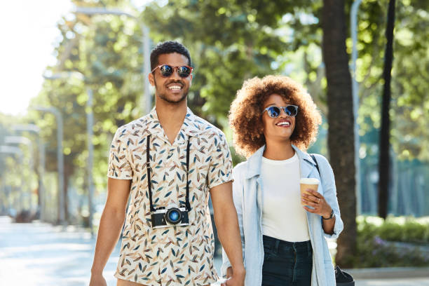 istock Smiling young couple walking on sidewalk in city 1175059603