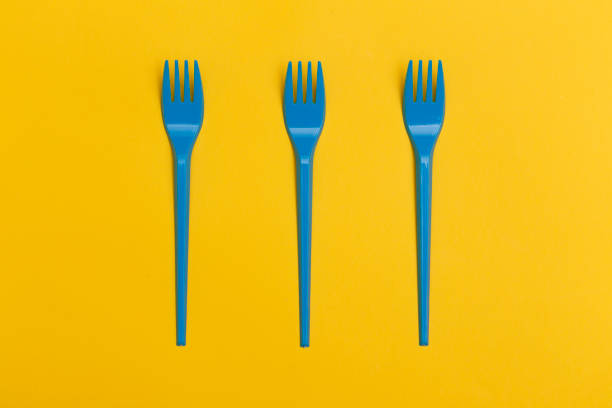 istock Three blue disposable plastic forks over a yellow background. 1175059733