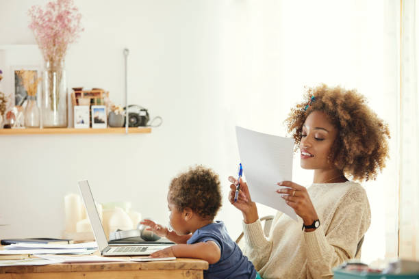 Mother with son working on laptop at home