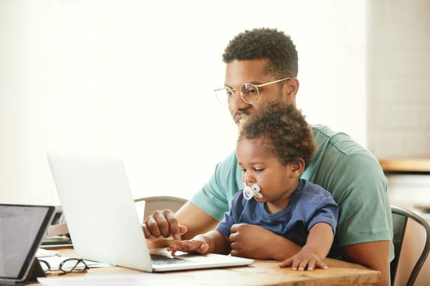istock Smiling father and son sitting with laptop 1175060839