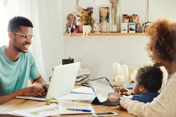 istock Father looking at mother and son while working 1175060851