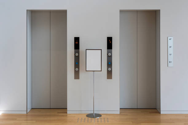 Grey Lobby and Two Lifts. Grey Lobby and Two Lifts. Couple Elevations and a Sign. japan small apartment stock pictures, royalty-free photos & images