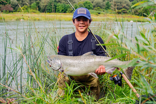 A proud young fisherman with a Chinook Salmon (King Salmon) he has caught.