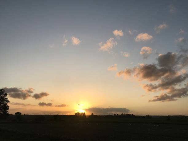 istock Sunset over land with clouds and blue sky 1175063556